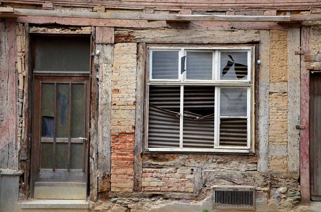 Distressed property exterior with broken window